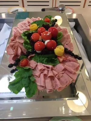 a plate of food with meat and vegetables on a table at Vrissaki Beach Hotel in Protaras