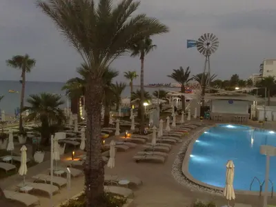 a view of a resort with a pool and palm trees at Vrissaki Beach Hotel in Protaras