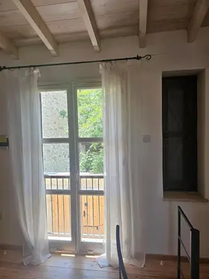 a large window with white curtains in a room at Lofou Maisonette in Lofou