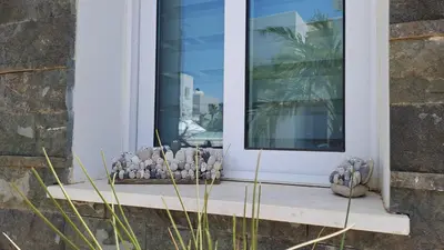 a window with a display of votives on a window sill at Relaxing Avra Villa with Private Pool & Garden Near Protaras in Paralimni