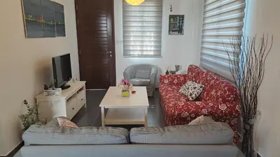 a living room with a red couch and a table at Relaxing Avra Villa with Private Pool & Garden Near Protaras in Paralimni