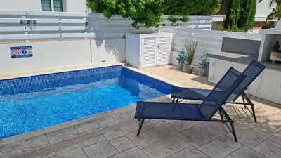 a blue chair sitting next to a swimming pool at Relaxing Avra Villa with Private Pool & Garden Near Protaras in Paralimni