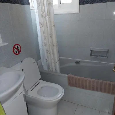 a bathroom with a toilet and a sink and a tub at ALEX FRUIT TREE HOME in Voroklini