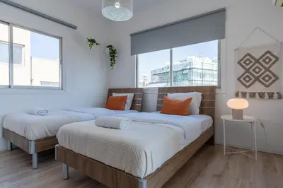 two beds in a room with two windows at Citrus 3-Bedroom Apartment in Larnaca in Larnaka