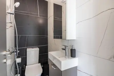a bathroom with a white toilet and a sink at Artemis 1-Bedroom Apartment in Larnaca in Larnaka