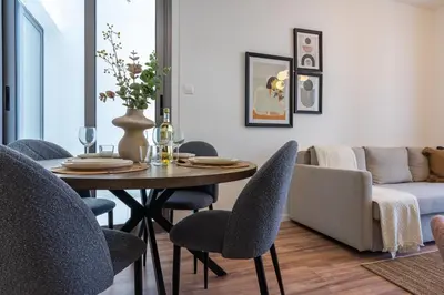 a dining room with a table and chairs and a couch at Latte's Prime 1-Bedroom Apartment in Larnaca in Larnaka