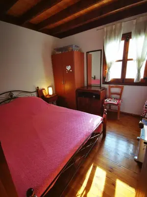 a bedroom with a red bed and a dresser at The Mouflon House Pedoulas in Nicosia