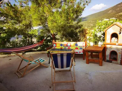 a patio with a hammock and a table and a chair at The Mouflon House Pedoulas in Nicosia