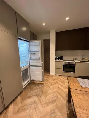 an empty kitchen with an open refrigerator and wooden floors at Natali's luxury apartment in Strovolos