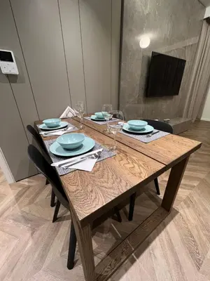 a wooden table with plates and wine glasses on it at Natali's luxury apartment in Strovolos