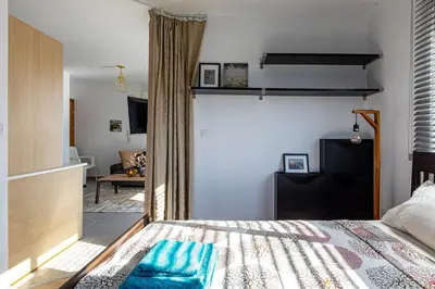 a bedroom with a bed and a living room at Cosy Apart at Lykavitos in Nicosia