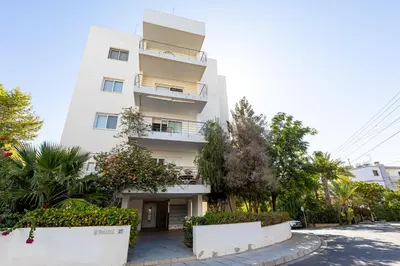 a white building with plants in front of it at Cosy Apart at Lykavitos in Nicosia