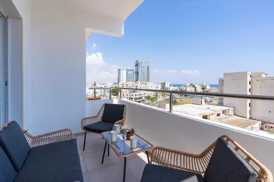 a balcony with two chairs and a table with a view at Diamond’s 2-Bedroom Apartment in Larnaca in Larnaka