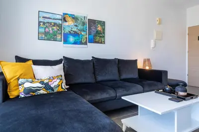 a living room with a black couch and a table at Diamond’s 2-Bedroom Apartment in Larnaca in Larnaka