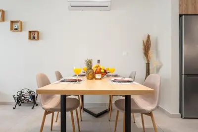 a dining room with a wooden table and chairs at Anchora in Paralimni