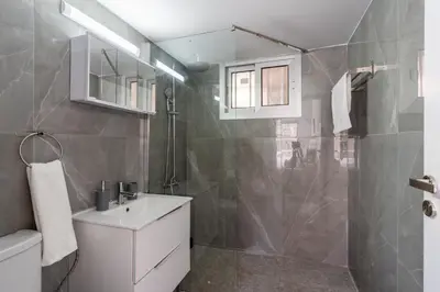 a bathroom with a white sink and a shower at Powder’s 1-Bedroom Retreat in Mackenzy, Larnaca in Larnaka