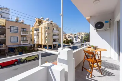 a balcony with a table and a view of a city at Powder’s 1-Bedroom Retreat in Mackenzy, Larnaca in Larnaka