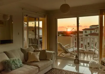 a living room with a couch and a balcony at Welcome to Thea Court in Paralimni