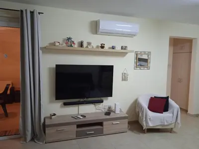 a living room with a flat screen tv on a wall at Xylophagou Rest and Relax 3 Ayia Napa Larnaca 1 bedroom apartment in Xylophaghou