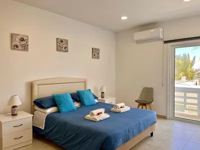 a bedroom with a blue bed with towels on it at Larnaca BeachHouse in Larnaka