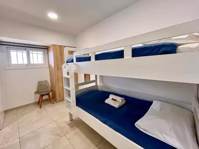 a bedroom with two bunk beds with blue sheets at Larnaca BeachHouse in Larnaka