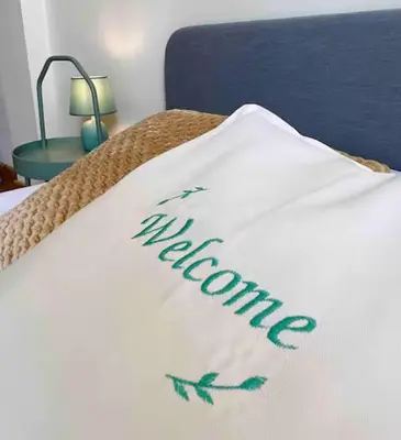 a white blanket with the word welcome on a bed at Nicosia City Centre Luxury Renovated Apartment in Nicosia