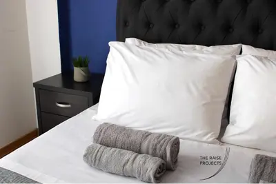 a bed with white pillows and two towels on it at Raise Limassol Urban Escape in Limassol