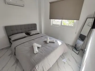 a bedroom with a bed with two towels on it at Maestro I Apartment in Larnaka