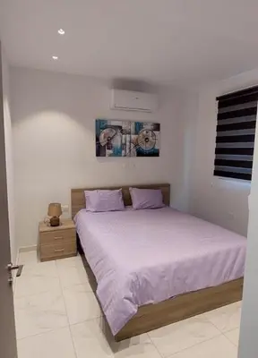 a white bedroom with a bed with purple sheets at Smart Living-2Bed Pallouriotissa, Nicosia in Nicosia