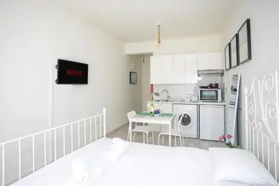 a room with a bed and a kitchen with a table at Palmove Makenzie Studio 4 in Larnaka