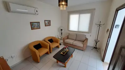 a living room with two chairs and a table at Dream Beach House Steps from the Sea & Free Parking in Protaras