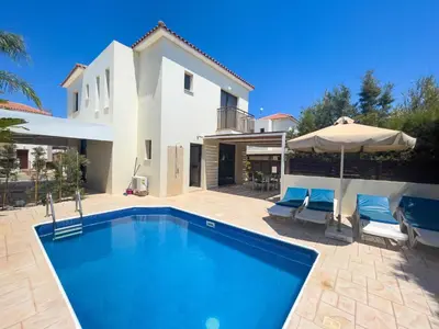 a villa with a swimming pool and a house at Fotini Villas in Protaras