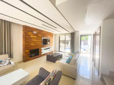 a living room with a couch and a tv at Fotini Villas in Protaras
