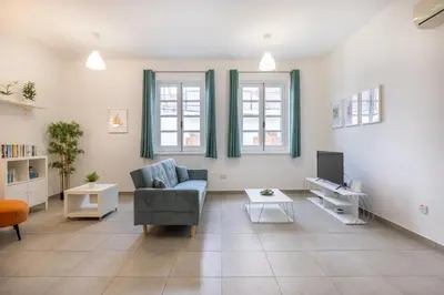 a living room with a couch and a tv at Pageant Homes in Nicosia