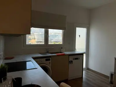 a kitchen with a sink and a washing machine at Sunny Rooms in Limassol
