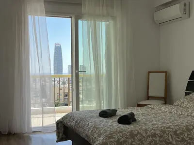 a bedroom with a bed and a large window at Sunny Rooms in Limassol