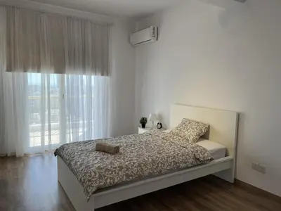 a bedroom with a bed and a large window at Sunny Rooms in Limassol