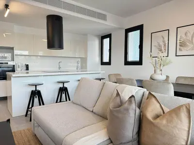 a living room with a couch and a kitchen at Phaedrus Living: White Hills Suites City View in Aglantzia