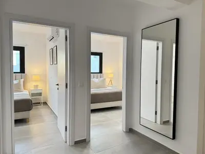 a bedroom with a mirror and a bed in a room at Phaedrus Living: White Hills Suites City View in Aglantzia
