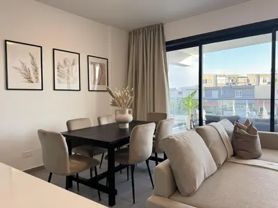a living room with a table and a couch at Phaedrus Living: White Hills Suites City View in Aglantzia