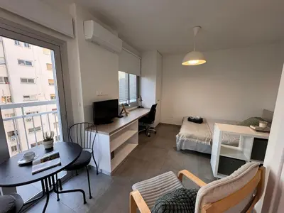 a living room with a bed and a desk with a television at Cityscape Urban Apts in Nicosia