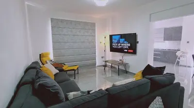 a living room with a couch and a tv at STAY Centro Apartment in Larnaka
