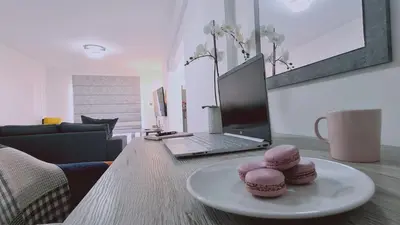 a table with two cookies on a plate with a laptop at STAY Centro Apartment in Larnaka