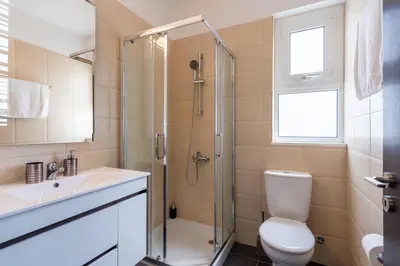 a bathroom with a shower and a toilet and a sink at Harbor Apartments in Larnaca in Larnaka