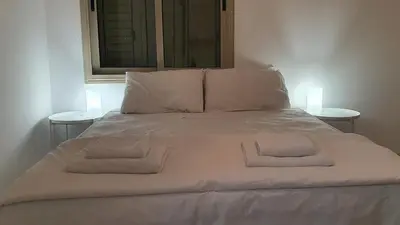 a large white bed with two white towels on it at BLUE LUXURY APARTMENT (BREAKBOOKING CY-SERVICES LTD) in Limassol