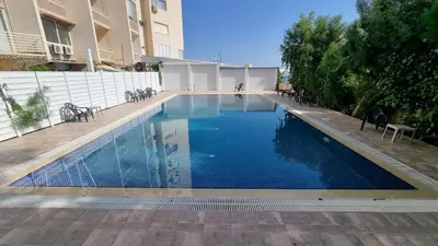 a swimming pool with blue water in a building at Stylish Beach Apt w/ Sea View + Pool + 200Mbit in Larnaka