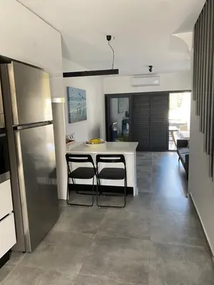a kitchen with a table and two stools at Green Bay Area Apartment in Protaras