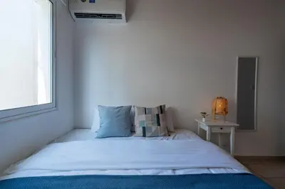 a bedroom with a white bed with a window at Laurel 2-Bedroom Apartment in Larnaca in Larnaka