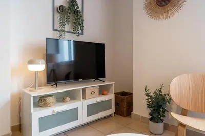 a flat screen tv sitting on top of a white entertainment center at Laurel 2-Bedroom Apartment in Larnaca in Larnaka