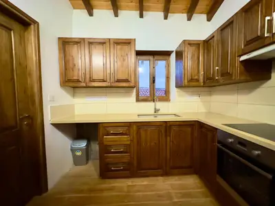 a kitchen with wooden cabinets and a sink at Αρχοντικό Αλεξάνδρου in Kakopetria